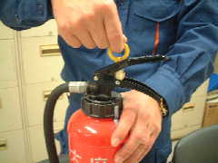 写真:消火器栓のピンを持つ様子