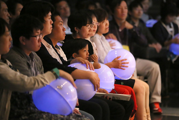 光るサウンドハグを抱える観覧者