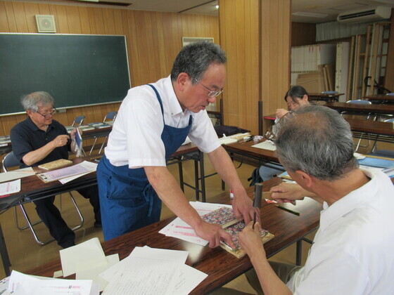 重ねた和紙に糸を通すための穴を開けている画像