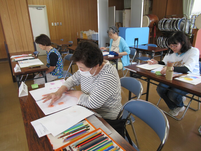 色鉛筆の芯をカッターで削って粉にし、指で塗っている画像